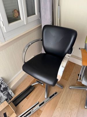 a black chair sitting in front of a window in a room