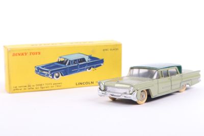 toy car in front of boxed box on white surface with box in background