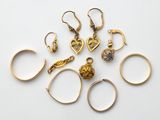 un ensemble de bagues et de boucles d'oreilles en or posées sur une surface blanche