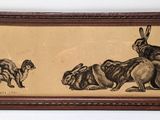painting of a rabbit and a dog in a wood frame on a wall