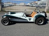 une petite voiture verte et blanche garée dans la rue