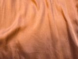 an image of a bed with a brown sheet and a pillow