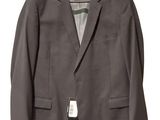 a gray jacket hanging on a hanger on a white wall