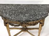 an antique marble topped table with gold legs and a black marble top
