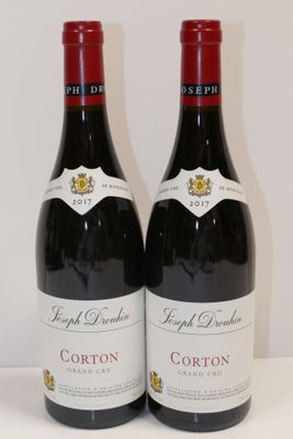 deux bouteilles de vin rouge posées sur une table blanche