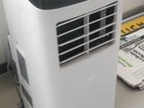 a small air conditioner sitting on the floor next to a chair