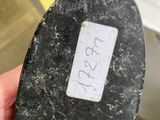 someone is holding a piece of metal with a tag on it