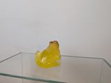 a yellow plastic frog sitting on a glass table