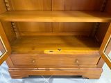a wooden cabinet with two doors open on the floor