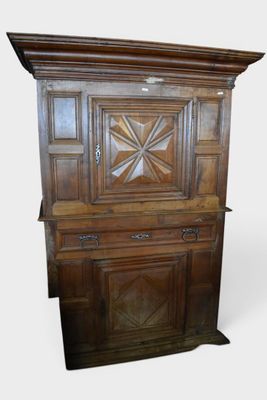 une vieille armoire en bois ornée d'un motif en forme d'étoile sur le dessus