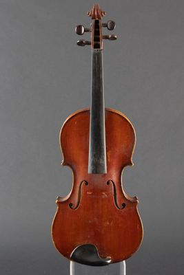 an old violin sitting on a stand against a gray background
