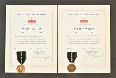 Deux médailles et un certificat sont exposés sur une table