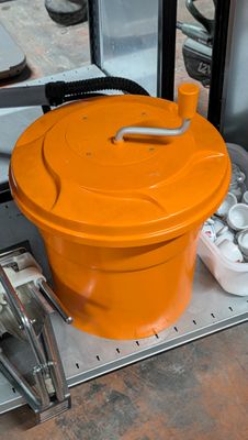un seau orange posé sur un plateau en métal