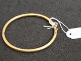 a close up of a gold bracelet with a tag on it