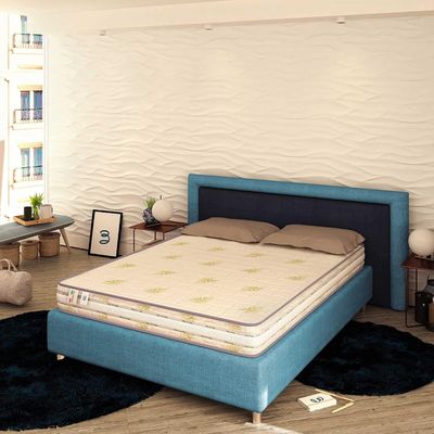 un lit qui se trouve dans une chambre avec une tête de lit bleue