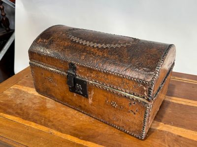 une vieille malle posée sur une table en bois dans une pièce