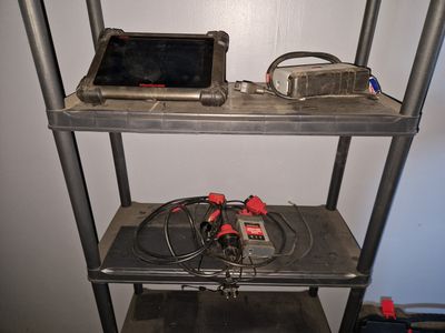 a metal shelf with a laptop and a tablet on it
