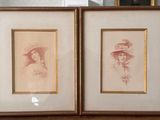 two framed pictures of women in hats on a table