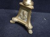 a gold vase with a skull on it sitting on a blue carpet