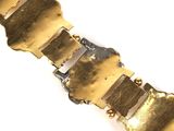 an image of a close up of a metal bracelet on a white surface