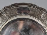 a silver plate with a picture of a woman in it