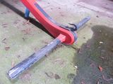 a red pipe cutter laying on the ground next to a red pipe cutter