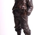 bronze statue of a boy with a hat on a rock