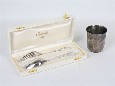 une cuillère en argent et une tasse en argent dans une boîte