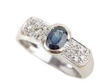 a close up of a diamond and sapphire ring on a white background