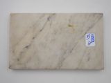 an image of a white marble slab with a blue sticker on it