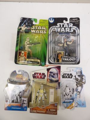 Plusieurs figurines de Star Wars sont exposées sur une surface blanche
