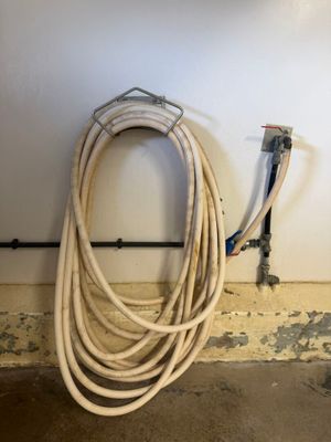 a hose that is sitting on the floor next to a wall