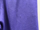 le dos d'un t-shirt violet suspendu à un cintre