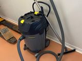 un aspirateur posé sur le sol de la pièce