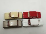 three toy cars are sitting side by side on a white surface