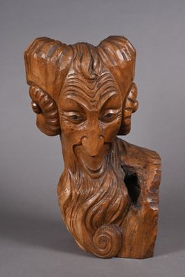 a close up of a wooden sculpture of a ram with long hair