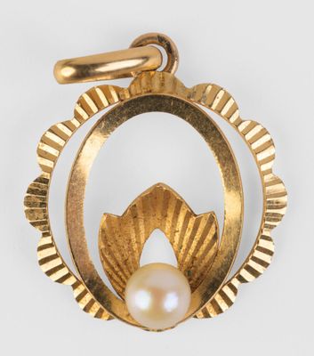 un gros plan d'un pendentif en or serti d'une perle