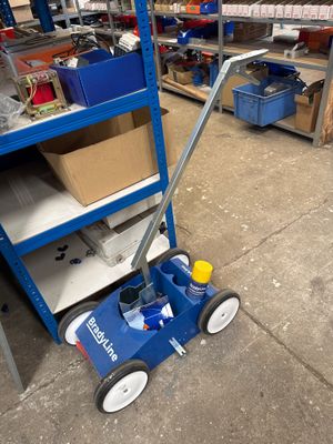 un chariot bleu sur lequel se trouve une balle jaune, dans un entrepôt