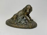 statue représentant un chien et un chat posés sur un rocher, sur fond blanc