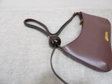 brown leather purse on a white cloth with a black cord