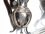 a silver tray with a silver vase on it
