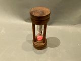 a small wooden hourglass with a red light inside