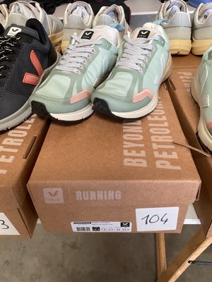 several pairs of running shoes sitting on top of boxes in a store