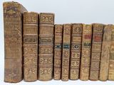 many old books lined up together on a white surface