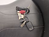 a car key and a cell phone on the back seat of a car
