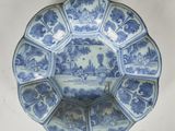 une assiette ancienne bleue et blanche sur laquelle est représenté un château