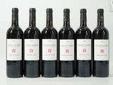 six bouteilles de vin sont alignées sur une surface blanche