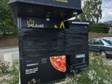 a sign that says pizzas on the side of the road