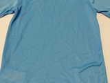 the back of a light blue shirt with a white logo on it
