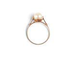 a close up of a pearl ring on a white surface